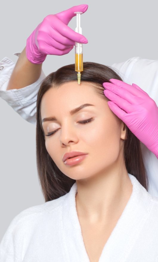 Cosmetologist does PRP therapy against hair loss and anti-dandruff of a beautiful woman in a cosmetic clinic.