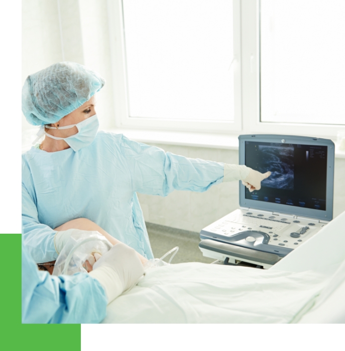 A cosmetic dermatologist amidst a varicose vein treatment monitoring the process with technology.